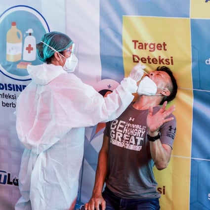 A man reacts as a health care worker collects a swab sample for Covid-19 testing in Medan, Indonesia’s North Sumatra, on Monday. Photo: EPA
