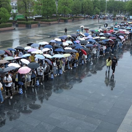 People line up in the rain to get vaccinated against the coronavirus in Fuyang, Anhui province, over the weekend. Photo: Reuters