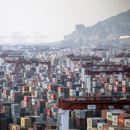 Shipping containers stand beneath gantry cranes at Yangshan port in Shanghai. World trade is gradually recovering but bringing the US-China trade war to a quick conclusion could make a marked difference. Photo: Bloomberg