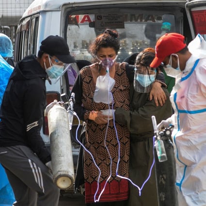 A Covid-19 patient breathes with the help of medical oxygen as she arrives at a hospital in Kathmandu, Nepal, on May 13. Photo: AFP