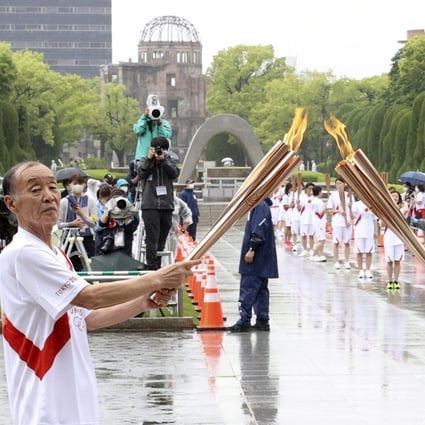 The Olympic flame is passed from torch to torch at Peace Memorial Park in Hiroshima, Japan. Photo: Reuters via Kyodo