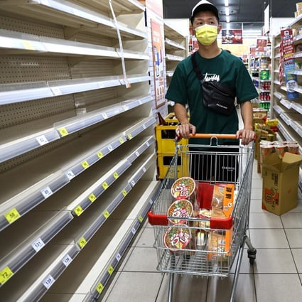 A person shops for groceries among near-empty shelves at a store in Taipei on May 17, following a surge in Covid-19 cases in Taiwan. Photo: Reuters