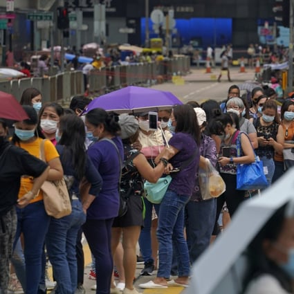 Domestic helpers line up at a Covid-19 testing centre in Hong Kong. Photo: AP