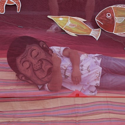 A protester wearing a mask of Philippine President Rodrigo Duterte pretends to sleep under a mosquito net to symbolise his inaction on the disputed South China Sea issues as they hold a rally outside the Chinese consulate in Metro Manila, Philippines, on May 7. Photo: AP