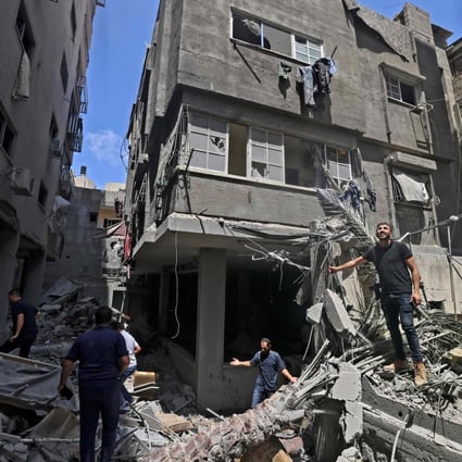 Palestinians inspect buildings damaged during Israeli air strikes in Gaza on May 20. Photo: AFP