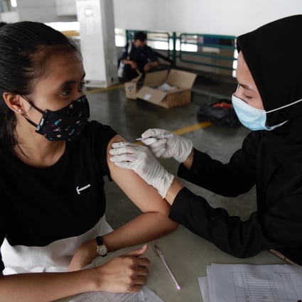 A woman receives a Covid-19 vaccine at a shopping mall in Jakarta, Indonesia. Photo: EPA