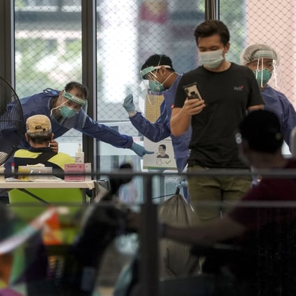 Medical personnel at a swab testing station in Singapore. Photo: EPA