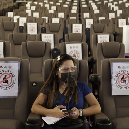A woman waits in a cinema-turned vaccination hub at a mall in Taguig, Philippines. Photo: AP