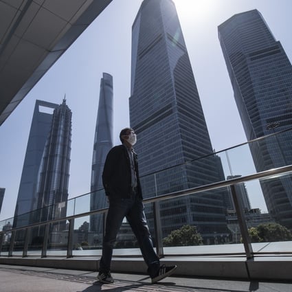 A pedestrian walks through the Lujiazui financial district in Shanghai on March 20, 2020. The foreign population in Shanghai has dropped by 22 per cent over the past decade Photo: Bloomberg