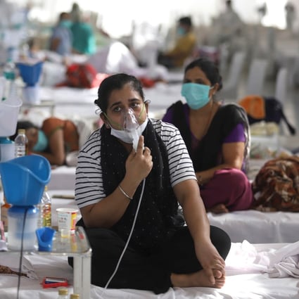 A Covid-19 patient uses an oxygen mask at a temporary care centre in New Delhi. Photo: DPA