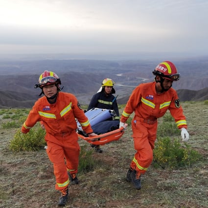 Rescuers carry a stretcher in Baiyin, Gansu province, where cold weather killed participants of an 100km ultramarathon on May 22. Photo: Reuters