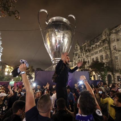 Chelsea fans celebrate in front of a giant replica of the Champions League trophy in Porto. Photo: AP