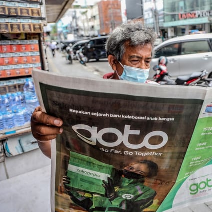 A man in Medan, North Sumatra, Indonesia, reads a newspaper with an advertisement about the creation of the country’s largest internet company, GoTo. A divergence in technological readiness across Southeast Asia has led to differing levels of digitalisation. Photo: EPA-EFE