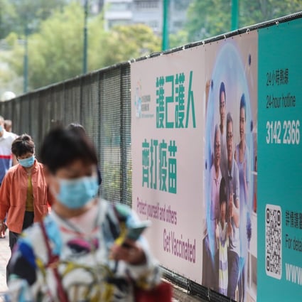 Pedestrians pass a poster in Causeway Bay on April 18 encouraging people to get vaccinated. Photo: Xiaomei Chen