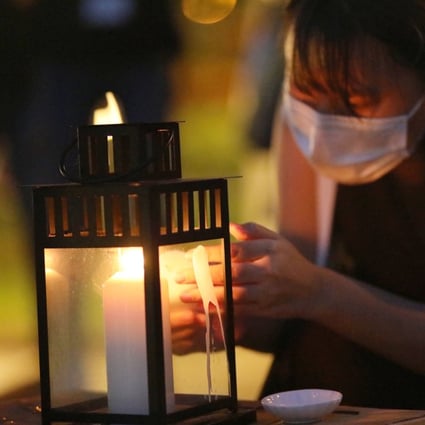 A woman lights a candle at the Kwun Tong waterfront on June 4, 2020, to mark the anniversary of the 1989 Tiananmen Square crackdown. Photo: K.Y. Cheng