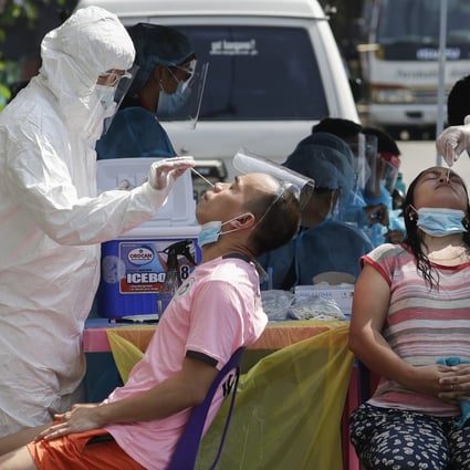 Health workers conduct a Covid-19 swab test on residents in Quezon City, Philippines. Photo: AP