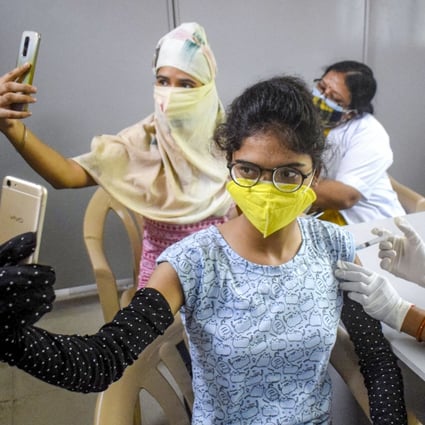 Women take selfies while receiving their Covid-19 vaccine shots in Allahabad, India. Photo: PTI/DPA