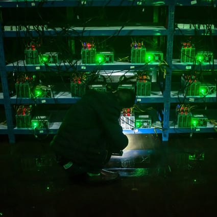 A bitcoin miner inspects a malfunctioning mining machine during his night shift at a mining facility in Sichuan on September 26, 2016. Beijing fears the electricity that massive mining facilities consume could hinder the country’s carbon neutrality goals. Photo: EPA