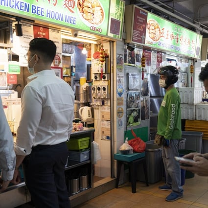 A Grab driver waits to pick up a food order in Singapore. Grab Holdings is delaying the completion of its merger that will allow it to go public in the United States. Photo: Bloomberg