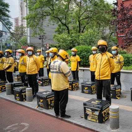 Food delivery couriers for Meituan during a morning briefing in Beijing in April. Photo: Bloomberg