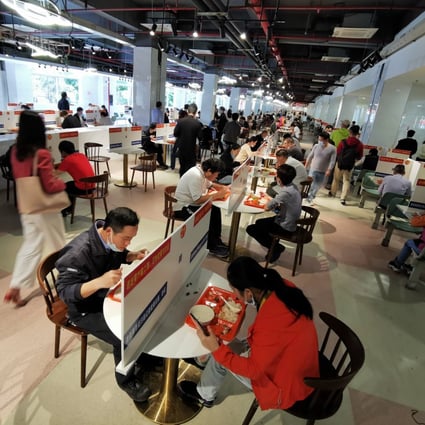 Workers have lunch on tables divided with barriers at a company canteen in the Longhua Science and Technology Park in Shenzhen, in southern China's Guangdong province. Photo: Xinhua