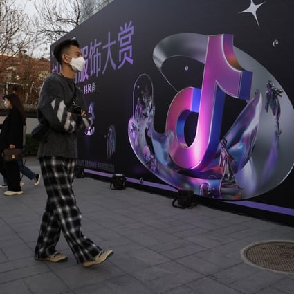 A woman speaks on her phone near the logo for Douyin in Beijing on March 31. Photo: AP