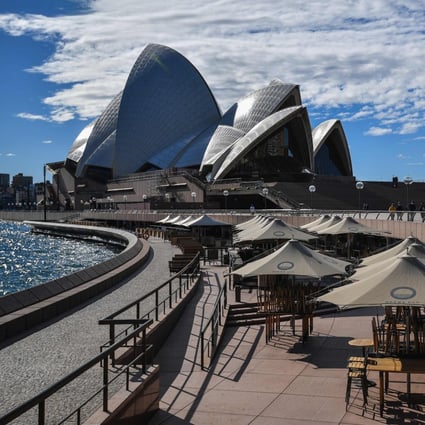 People walk near the Opera House in Sydney on Saturday. Photo: AFP