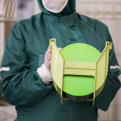 A worker holds a rack of silicon wafers at a semiconductor plant. There were nearly 512,000 people working in China’s chip industry at the end of 2019. Photo: Bloomberg