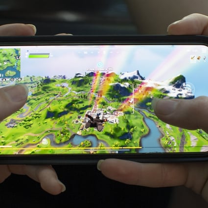 A teenage girl plays the video game Fortnite, on an Apple iPhone X in Billerica, Massachusetts, on August 24, 2020. Tencent owns nearly half of Epic Games, an investment now facing scrutiny in the US. Photo: EPA-EFE