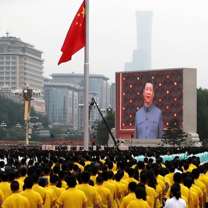 President Xi Jinping, seen on a giant screen, sings the national anthem during a flag-raising ceremony at the Tiananmen Square event on Thursday. Photo: Reuters