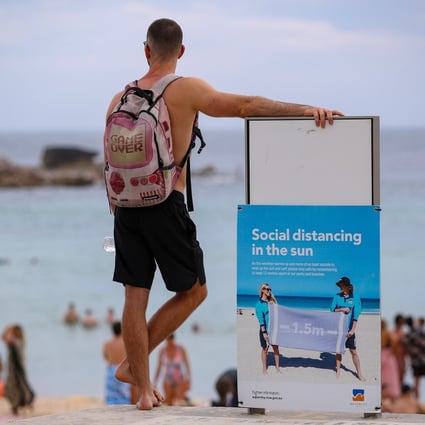 A man stands beside a notice board at Bondi Beach, Sydney, in January. Photo: Xinhua