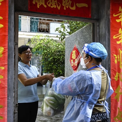 A community worker delivers daily necessities to a quarantined household in Ruili, Yunnan province, on Thursday. Photo: Xinhua via AP