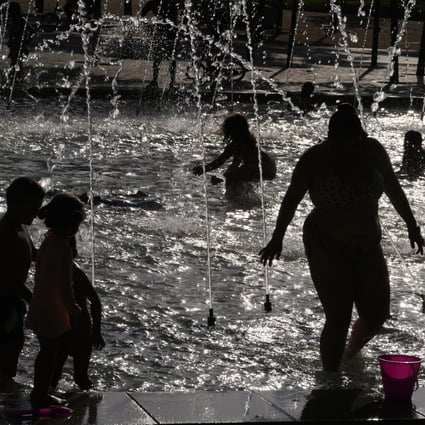 People cool off in a fountain in Madrid, Spain on Saturday. Chinese scientists have developed a fabric to help people stay cool as temperatures rise. Photo: AP