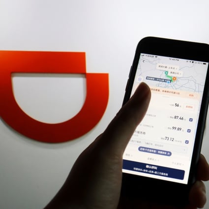 The app of Chinese ride-hailing giant Didi Chuxing is seen on a mobile phone in front of the company logo on July 1. Didi has become the subject of China’s first cybersecurity review, but the many different ministries involved suggest a broad scope. Photo: Reuters