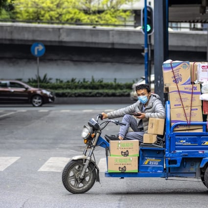 A man rides a delivery motorcycle on a street in a deserted workshop district and wears a mask in an attempt to protect himself from a coronavirus contagion in Guangzhou, Guangdong Province, China. Photo: EPA-EFE