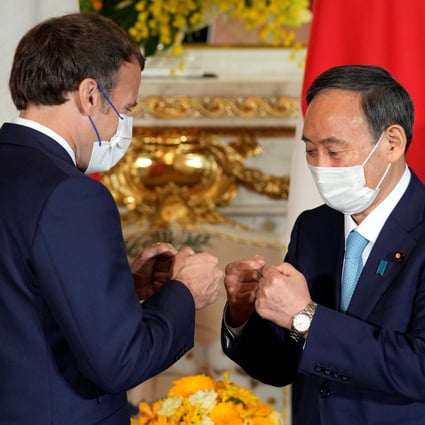 Japanese Prime Minister Yoshihide Suga (right) greets French President Emmanuel Macron in Tokyo on Saturday. Photo: Reuters