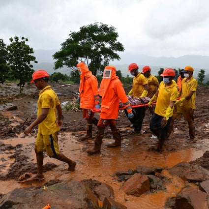 Target Disaster Response Force (TDRF) workers carry the body of a victim at the site of a landslide at Taliye, India on Saturday. Photo: AFP