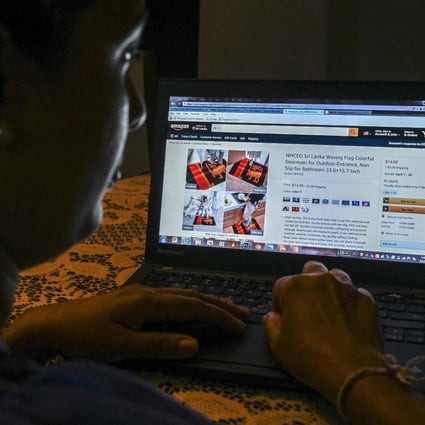 In this photo illustration a woman looks through a webpage of the online retail giant Amazon displaying Chinese-made doormats with the Sri Lankan flag design for sale in Colombo on March 12. Amazon has been cracking down on Chinese merchants this year, banning those that violate its rules like paying for positive reviews. Photo: AFP