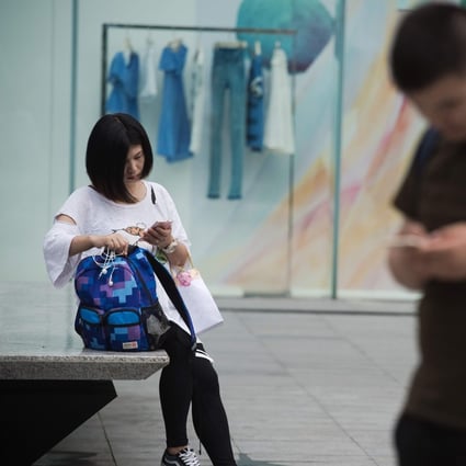 People use their smartphones along a street in the southern Chinese city of Shenzhen. Photo: AFP