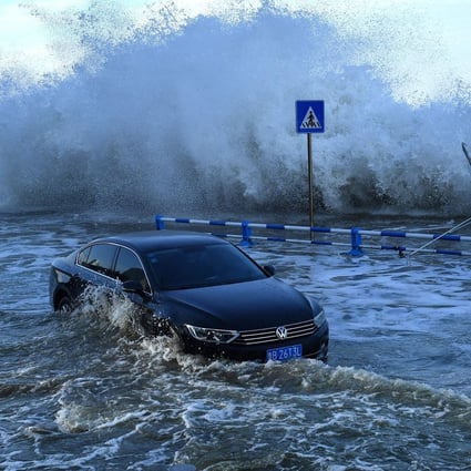 Waves surge over a barrier along the seacoast in Qingdao in China’s eastern Shandong province. Photo: AFP