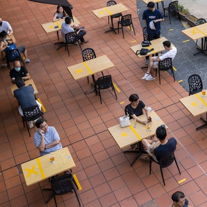 Customers sit at socially distanced tables outside a restaurant in Singapore. Photo: Bloomberg