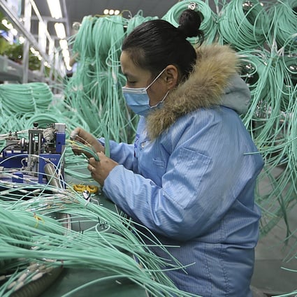A worker assembles optic fibre cables at a factory in Suixi in central China's Anhui province. Photo: AP