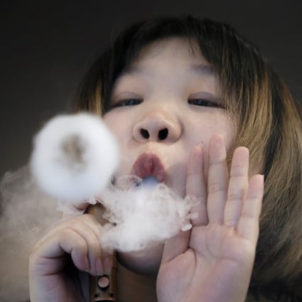 A saleswoman demonstrates vaping at the Vape Shop that sells e-cigarette products in Beijing, China. Photo: Reuters