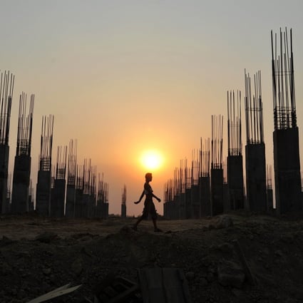 A construction worker walks past a construction site in Naypyidaw. Photo: AFP