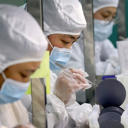 Employees handle silicon wafers in the clean room at Jiejie Semiconductor Company in Nantong, Jiangsu province, on March 17, 2021. Photo: STR/AFP