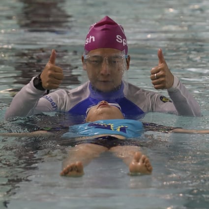 Splash Foundation’s swim student Ricky learning to do the back float with coach C.K. Kan. Photo: Xiaomei Chen