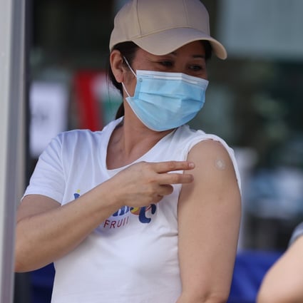 Two foreign domestic helpers after receiving their second dose of BioNTech vaccination for Covid-19 at Sun Yat Sen Memorial Park Sports Centre in Sai Ying Pun. Photo: Nora Tam