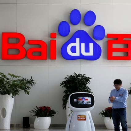 Men interact with a Baidu AI robot at its headquarters in Beijing. Photo: Reuters