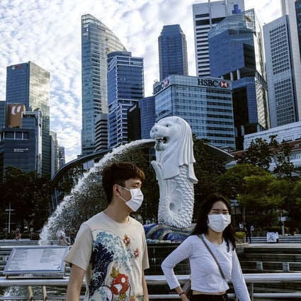 A couple in Singapore wear face masks while walking past the Merlion statue. Photo: AP