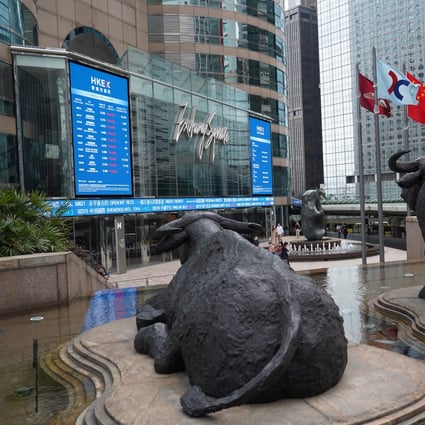 People walk past signage for Hong Kong Exchanges & Clearing Ltd. (HKEX) displayed at the Exchange Square complex in Central. Photo: SCMP / Sam Tsang